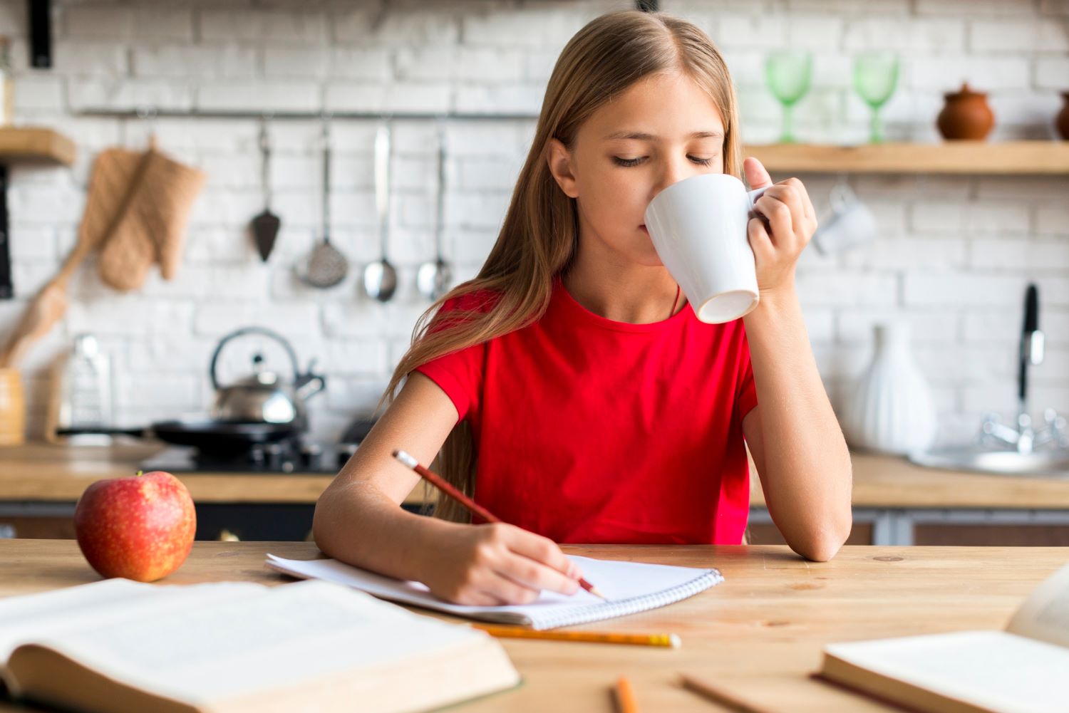 Teenage girl studying for exams while learning to understand her hormones and menstrual cycle.